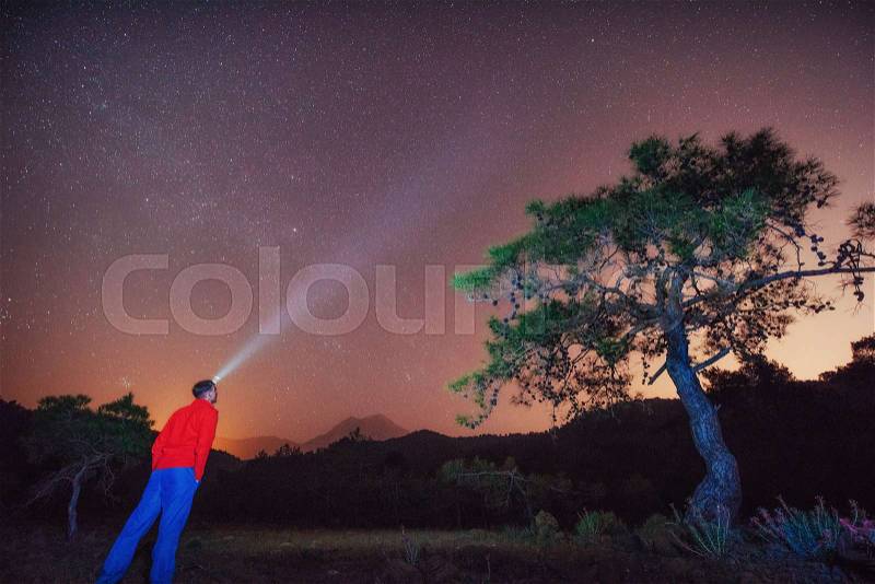 A person who feels on top of the world looking at the starry sky, stock photo