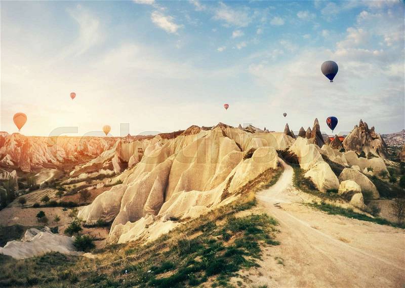 Hot air balloon flying over rock landscape at Cappadocia Turkey. Cappadocia with its valley, ravine, hills, located between the volcanic mountains in Goreme National Park, stock photo