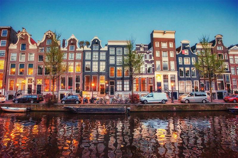 Fantastic sunset that shines on buildings and reflected in the water. Amsterdam is the capital and most populous city in Netherlands. , stock photo