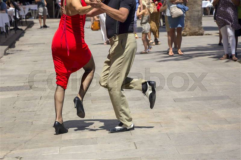 Street dancers performing tango in the street among the people, stock photo