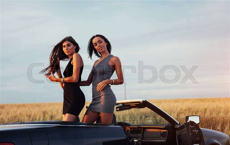 Two women in a black car on the roadside roads, stock photo