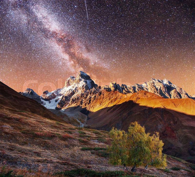 Fantastic collage. Starry sky above snow-capped mountain peaks. Autumn landscape. Main Caucasian Ridge. Georgia. Europe, stock photo