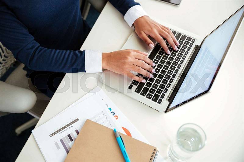 Top view of african business woman in dress using laptop in office. Cropped image, stock photo