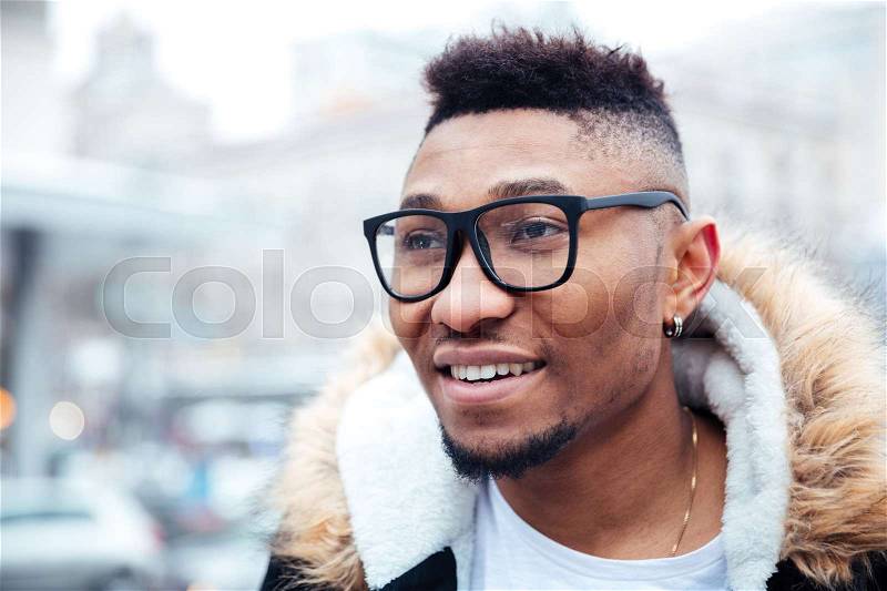 Portrait of african happy man walking on the street. Looking aside, stock photo
