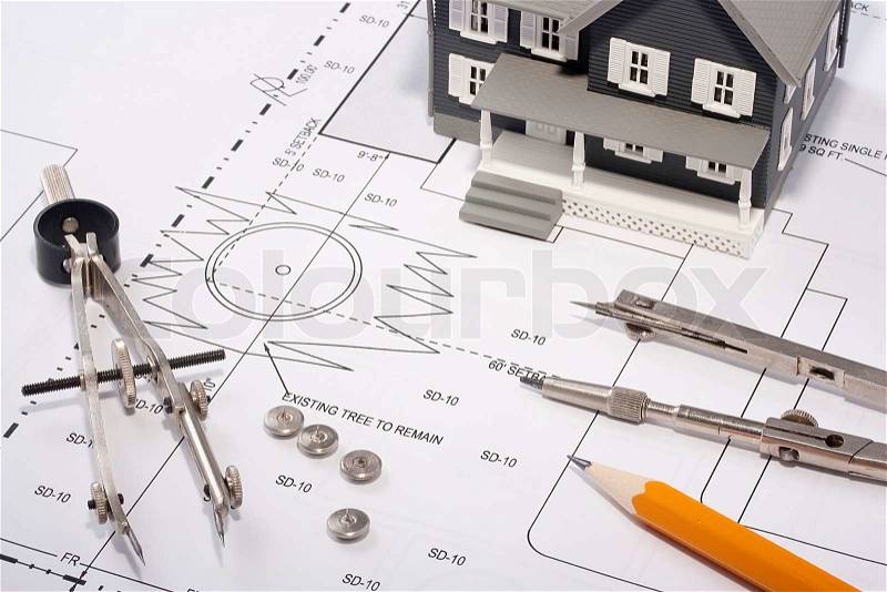 House model and drafting tools on a construction plan, stock photo