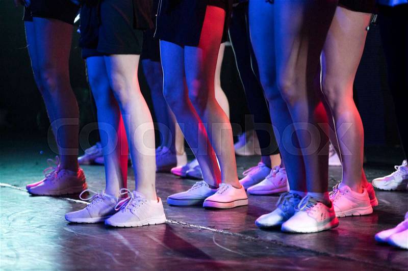 Low view of group of unrecognizable dancers performing on stage. Close up view on legs, stock photo
