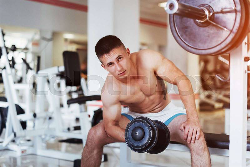 Portrait of a beautiful athletic guy muscles with weights in the gym. Sport. Fitness, stock photo