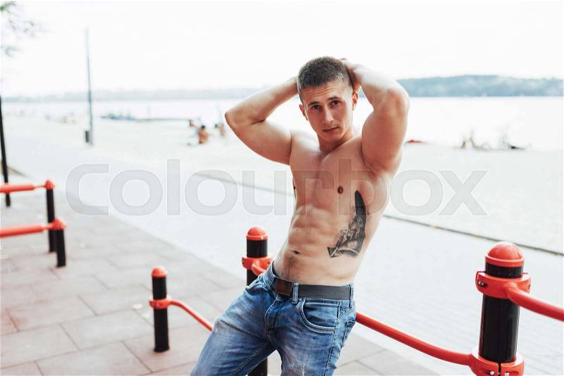 Strong young athlete engaged on the playground. Exercises on the bars outdoors. Fitness. Sport. Exercises, stock photo