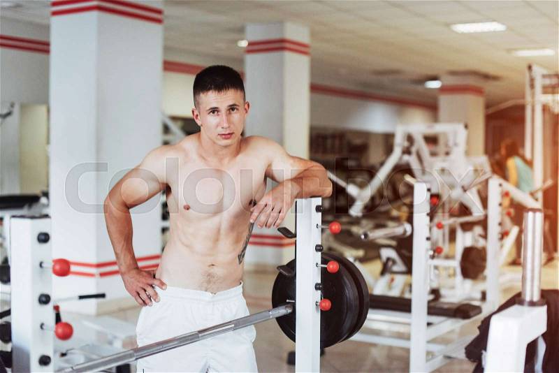 Portrait of a beautiful and attractive young man with muscular body relaxing in the gym, showing strong chest, stock photo