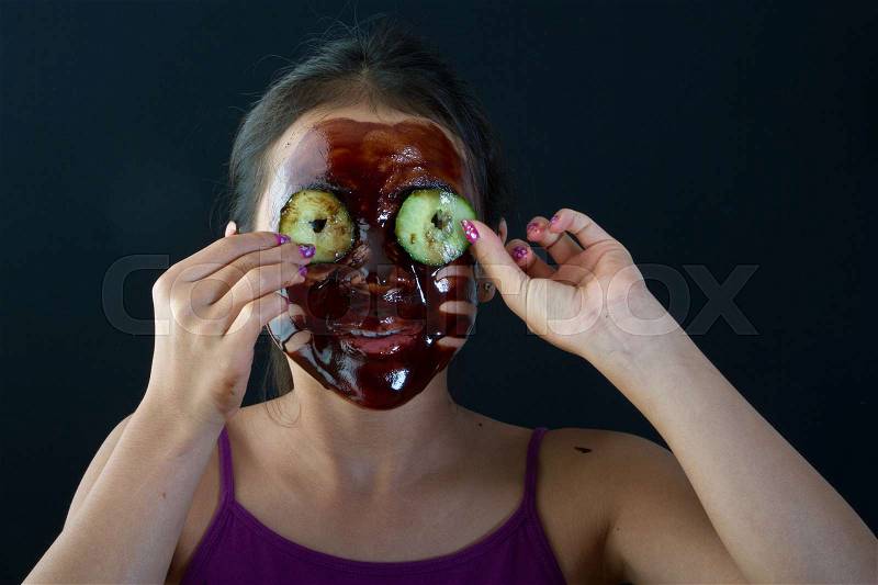 Young asian girl having fun with a chocolate mask, stock photo