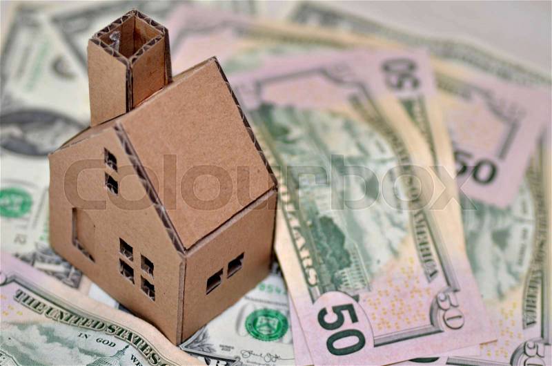 Miniature paper made house stand on money, stock photo