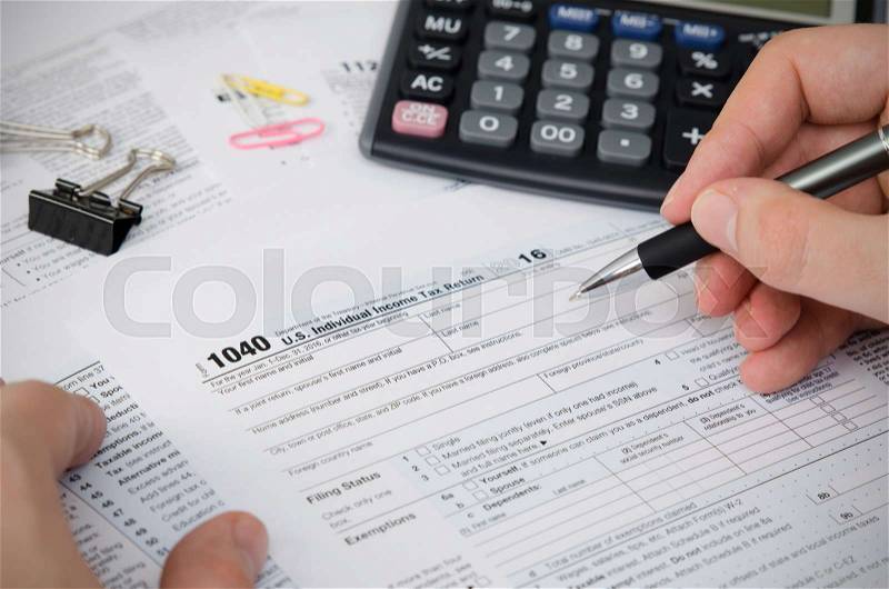 Man filling US tax form. tax form us business income office hand fill concept, stock photo