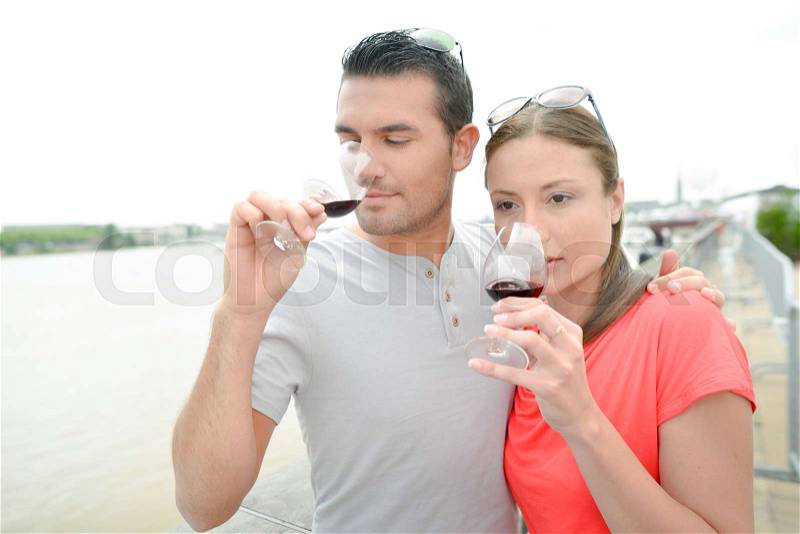 Couple drinking wine by the river, stock photo
