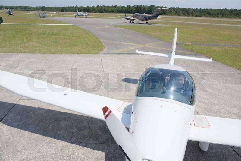 Pilot in aircraft with thumbs up, stock photo