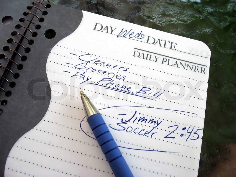 A daily planner filled with a busy parent\'s daily activities, stock photo