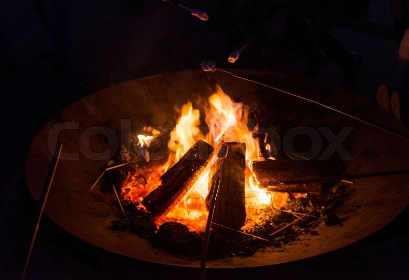 Heating and warming sweet marshmallow in the campfire, stock photo