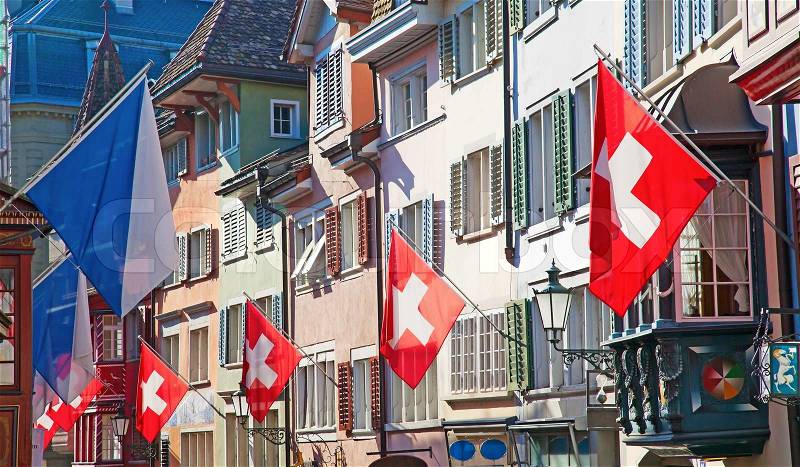Ancient street Augustinergasse in Zurich decorated with swiss flags, stock photo
