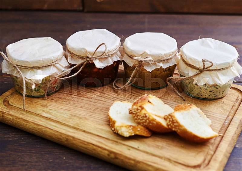 Close-up of opened jars with ready-to-it food standing on the wooden board. Lunchtime food. Portable jars , stock photo