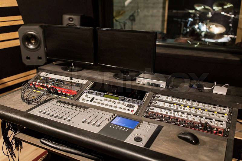 Music, technology, electronics and equipment concept - mixing console and computer monitors at sound recording studio, stock photo