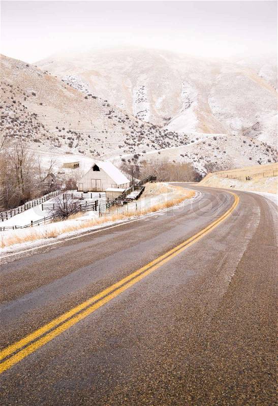 An icy road leads through country scene farm ranch hillside highway 71, stock photo