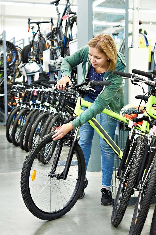 Attractive woman testing the bike in the store, stock photo