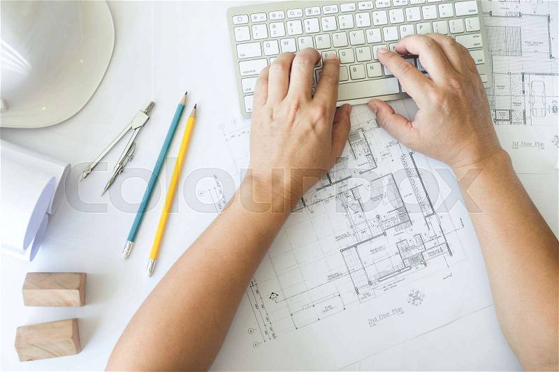 Architect or engineer working on keyboard blueprint and architecture mode in office room, Construction concept, stock photo