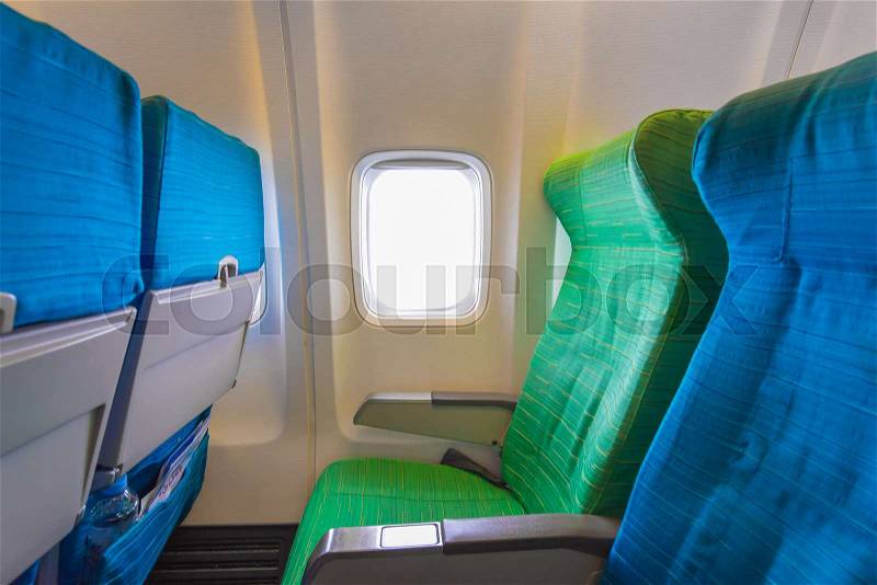 Airplane seat near windows in cabin of huge aircraft, stock photo
