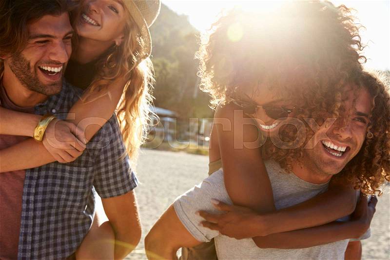 Two young couples piggybacking at the beach, Ibiza, Spain, stock photo