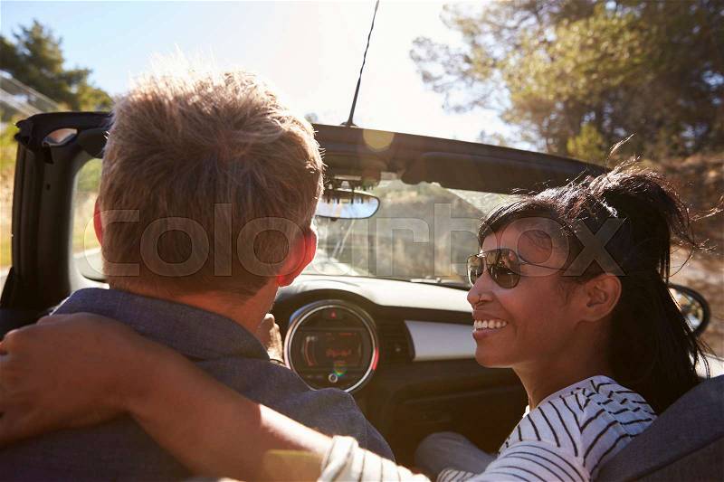 Couple driving, woman looking at man, close up back view, stock photo