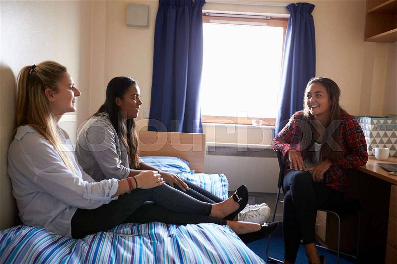 Female Students Relaxing In Bedroom Of Campus Accommodation, stock photo