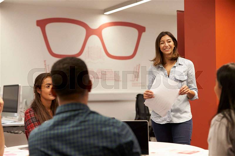 Teacher Talking To Students In College Class, stock photo