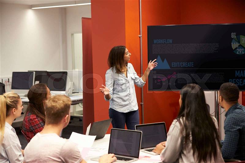 Teacher Talking To Students In College Class, stock photo