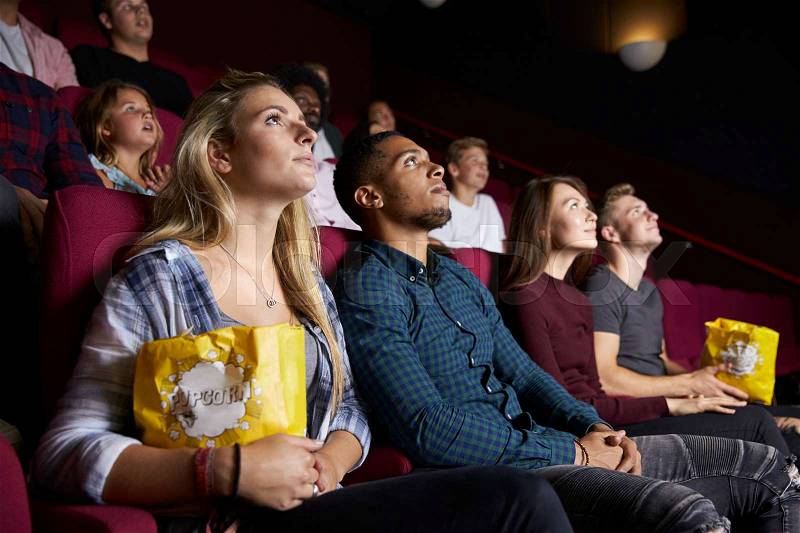 Young Couple In Cinema Watching Film And Eating Popcorn, stock photo