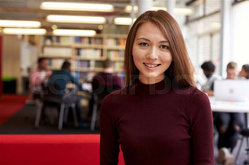 Portrait Of Female University Student Working In Library, stock photo