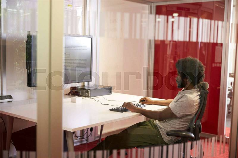 Male Student Working In Classroom With Large Screen, stock photo