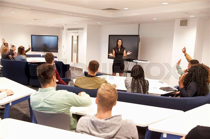 University students study in classroom with female lecturer, stock photo