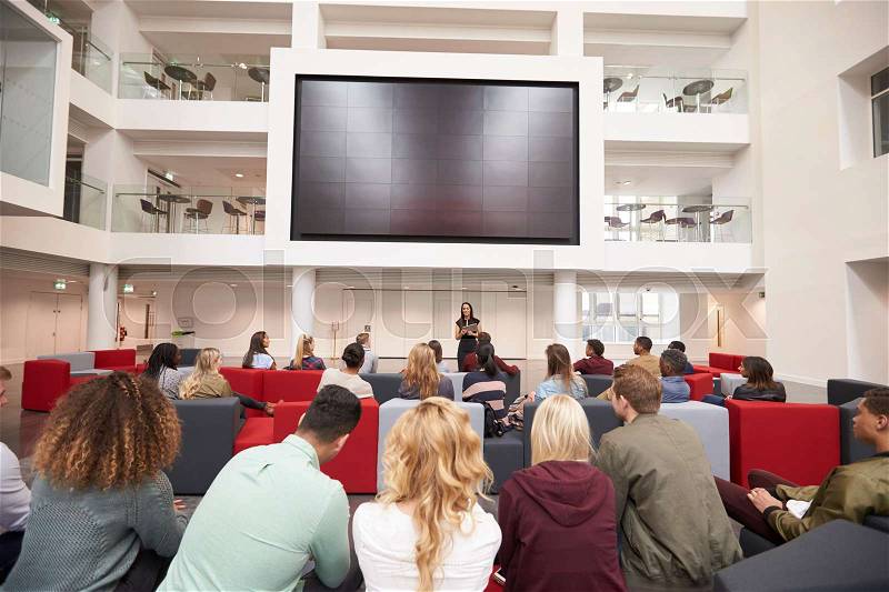 Back view of students at a lecture in a university atrium, stock photo
