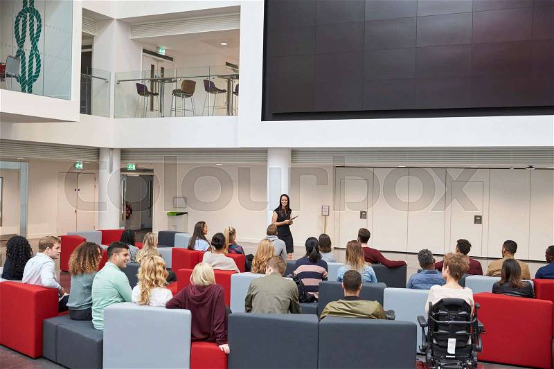 Students at a lecture in university atrium, back view, stock photo