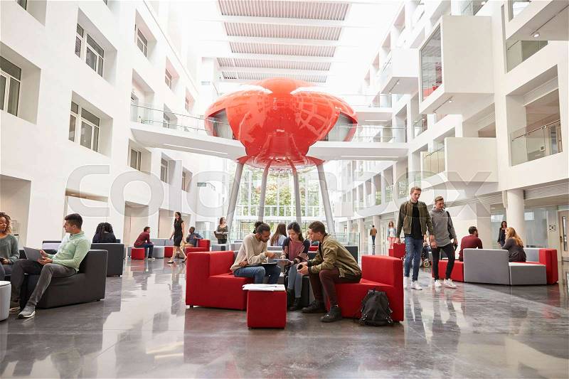 Students socialising in the lobby of modern university, stock photo