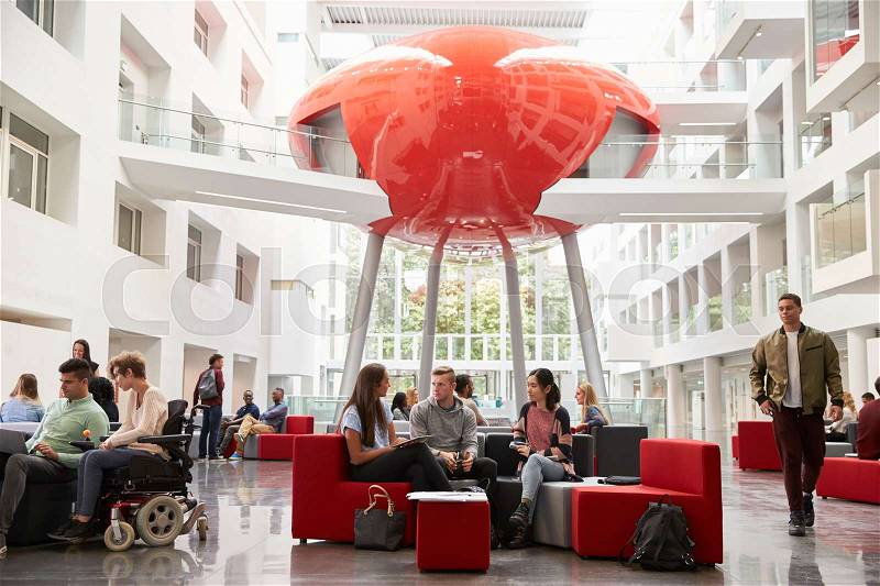 Groups of students meet in the lobby of their university, stock photo