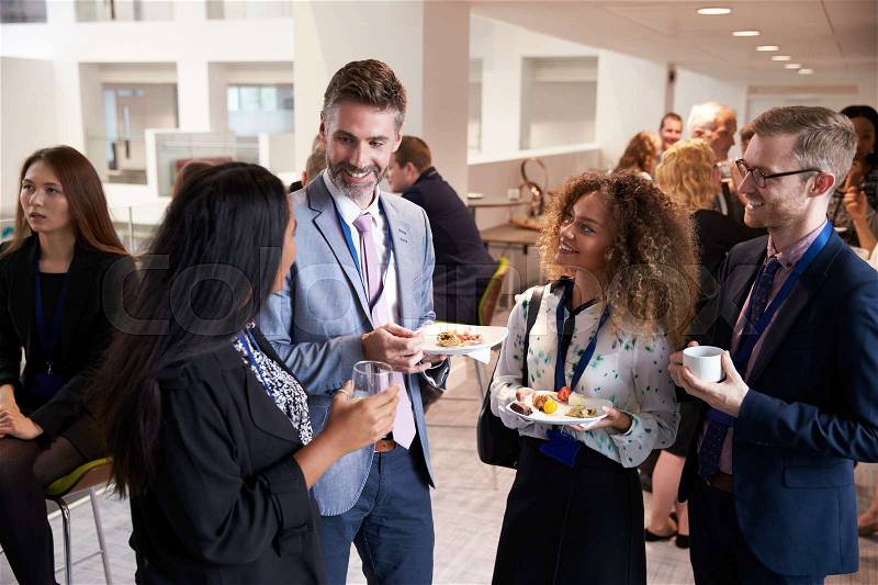Delegates Networking During Conference Lunch Break, stock photo