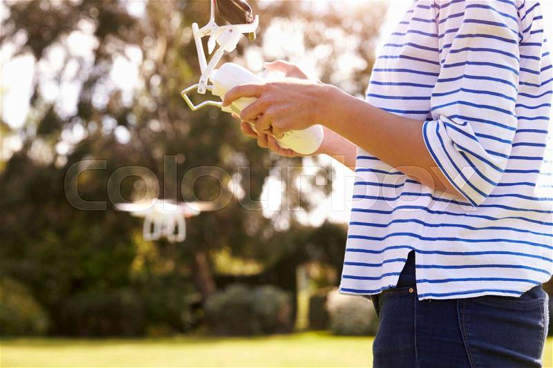 Close Up Of Woman Flying Drone Quadcopter In Garden, stock photo