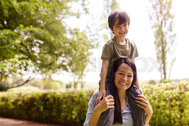Mother Giving Son Ride On Shoulders During Walk, stock photo