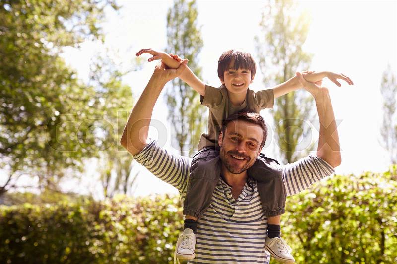 Father Giving Son Ride On Shoulders During Walk, stock photo