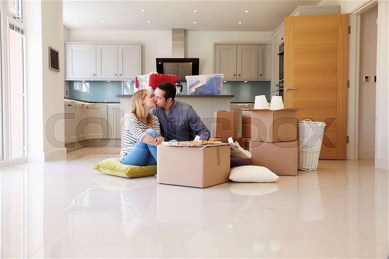Couple Celebrating Moving Into New Home With Pizza, stock photo