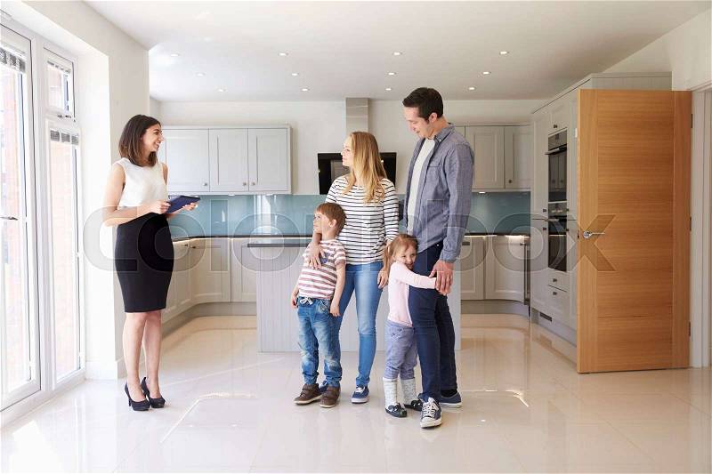 Realtor Showing Young Family Around Property For Sale, stock photo