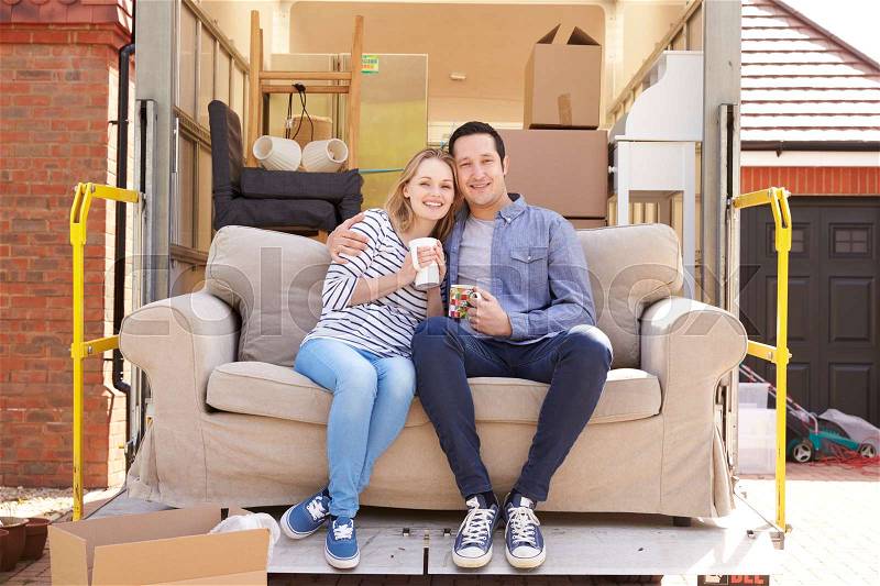 Couple With Sofa On Tail Lift Of Removal Truck Moving Home, stock photo