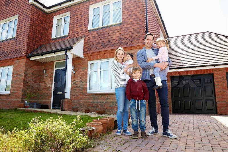 Portrait Of Young Family Standing Outside New Home, stock photo