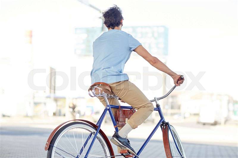 People, style and lifestyle - hipster man riding fixed gear bike on city street, stock photo