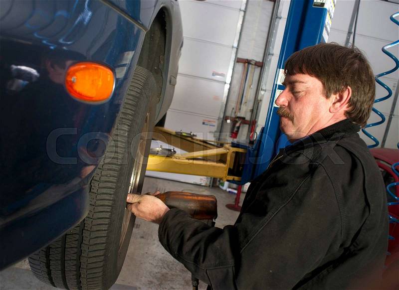 Automotive Technician Uses Pneumatic Impact Wrench Auto Repair Brakes Tire, stock photo